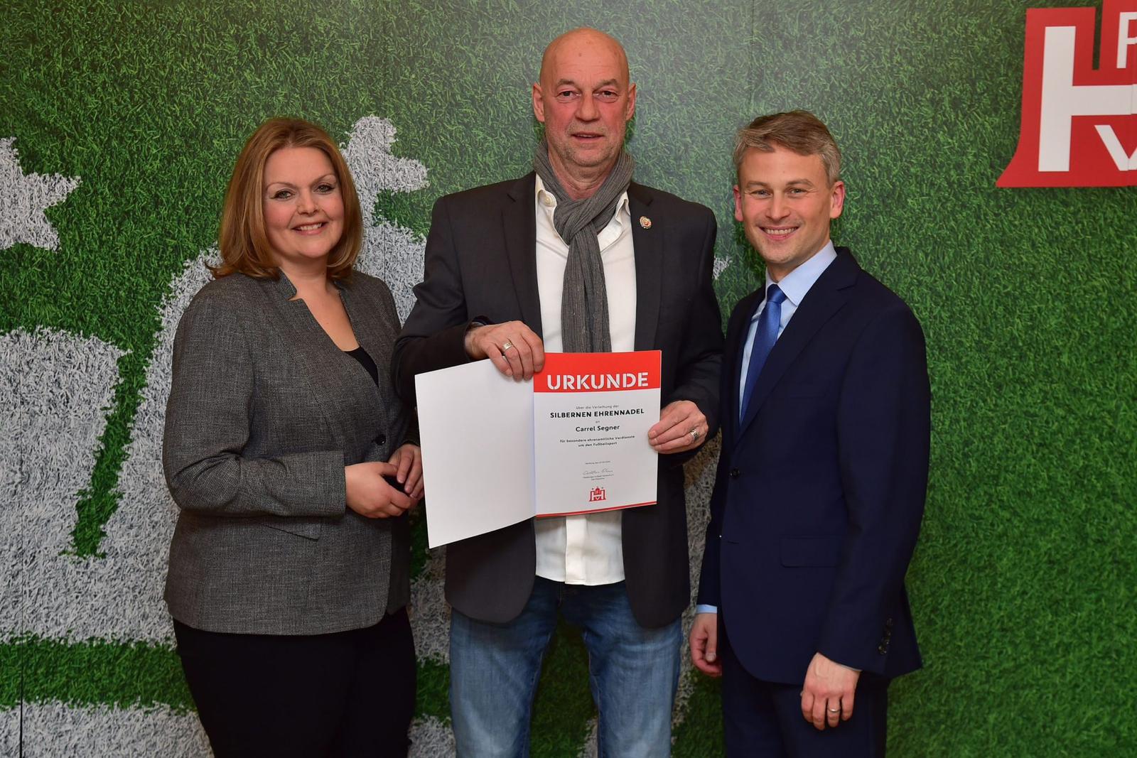 NTSV-Abteilungsleiter Carrel Segner erhält die Silberne Ehrennadel des Hamburger Fußball-Verbands von deren Präsident Christian Okun und Vizepräsidentin Kathrin Behn.